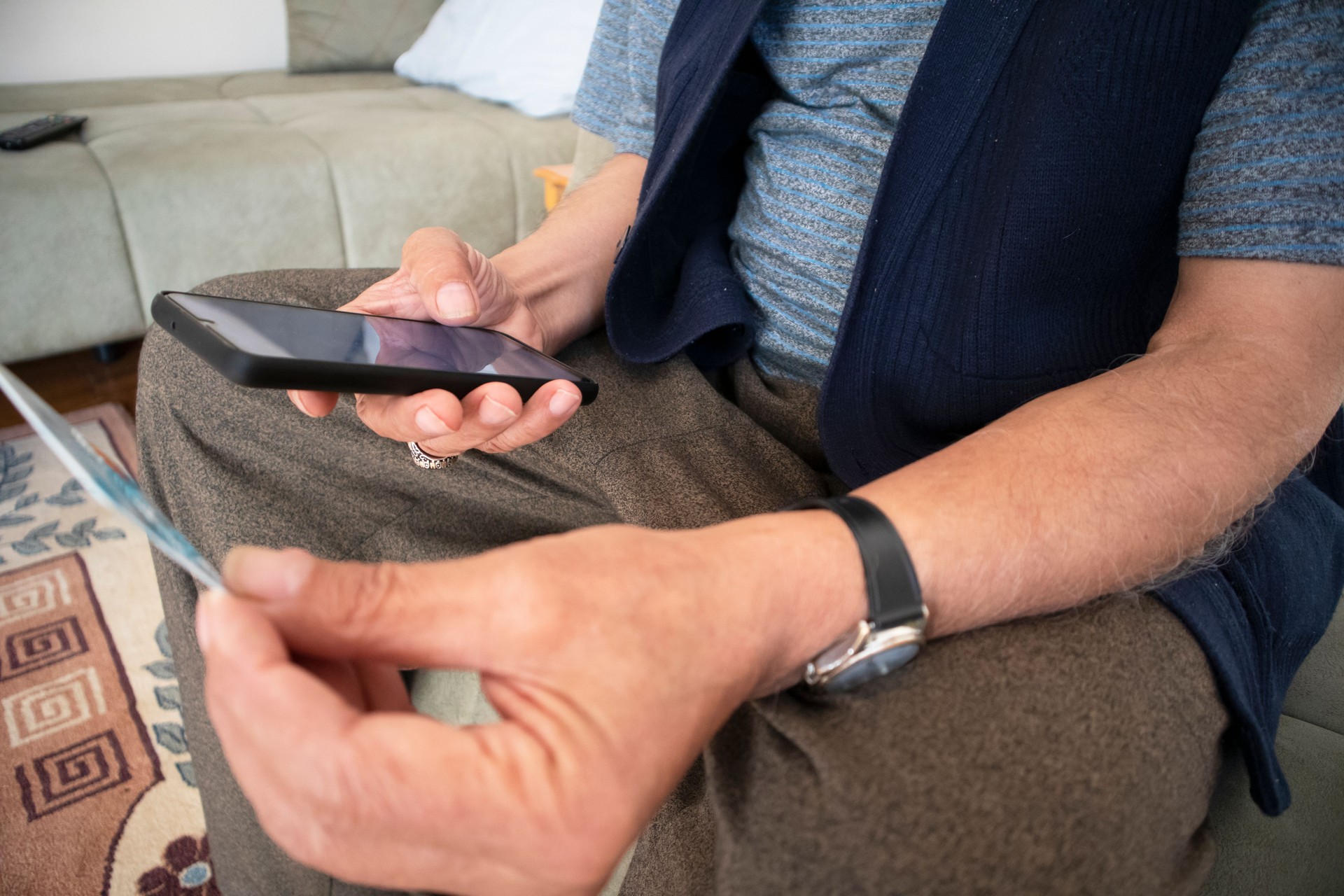 Gros plan sur un homme mature utilisant un téléphone, tenant une carte de crédit en plastique